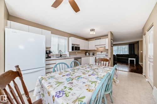 Kitchen featuring white cabinetry, a built-in microwave, and a stainless steel sink with a gooseneck faucet - 11831 9 Avenue, Edmonton, AB 