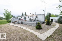 Spacious outdoor deck with latticework skirting and direct access to the white-sided residence - 