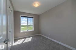 Interior room featuring neutral paint, gray carpeting, a single window with a roller shade, and a flush mount ceiling fixture - 
