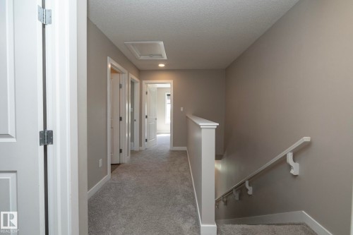 Upper-level hallway featuring soft gray carpeting and neutral wall tones - 2610 Maple Way, Edmonton, AB 