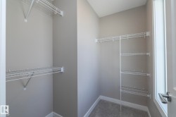 Spacious closet featuring an extensive wire shelving system, multiple hanging rods, and light gray wall finishes - 