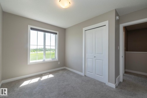 Carpeted room with neutral wall tones and a window featuring a roller shade - 2610 Maple Way, Edmonton, AB 