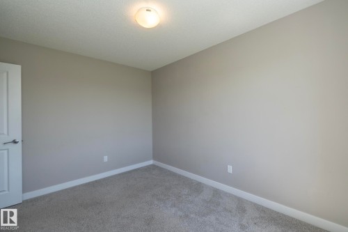 Neutral-toned room featuring a single door with silver hardware - 2610 Maple Way, Edmonton, AB 