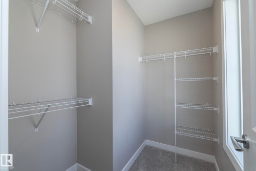 Spacious closet featuring an extensive wire shelving system, multiple hanging rods, and light gray wall finishes - 2610 Maple Way, Edmonton, AB 