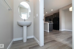Pedestal sink and oval mirror in a neutral-toned powder room - 