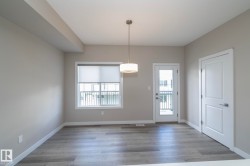 Spacious room with wood-finish flooring, neutral paint palette, and white baseboards - 