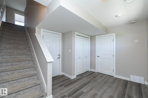 Lower level featuring wood-finish flooring, two panel doors, and bifold closet doors - 2610 Maple Way, Edmonton, AB 