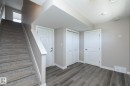 Lower level featuring wood-finish flooring, two panel doors, and bifold closet doors - 2610 Maple Way, Edmonton, AB 