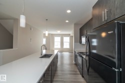 Modern kitchen featuring a large island with an undermount sink and gooseneck faucet - 