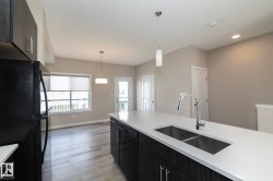 Kitchen island with a double basin sink, chrome pull-down faucet, and white countertop - 