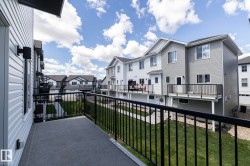 Private exterior balcony with dark gray flooring and black metal railings - 