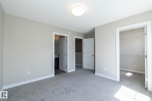 Carpeted room with light gray walls, white trim, and a semi-flush mount ceiling light - 2610 Maple Way, Edmonton, AB 