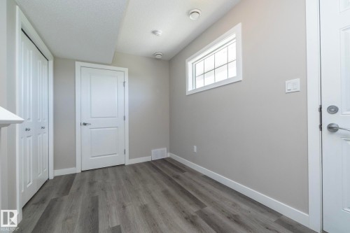 Bright interior space featuring wood-finish flooring and neutral wall tones - 2610 Maple Way, Edmonton, AB 