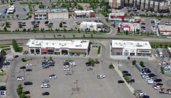 Aerial perspective of a commercial district featuring multiple retail buildings with dedicated parking areas - 