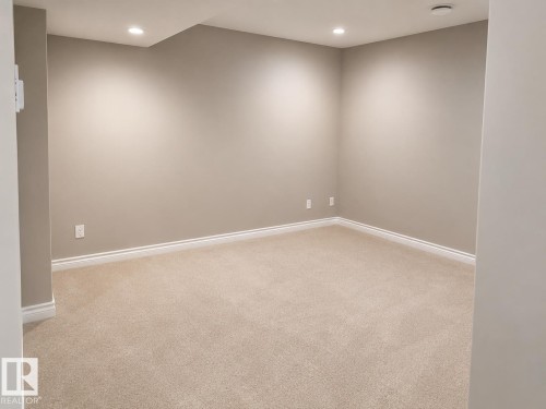 Neutral-toned carpeted room featuring recessed lighting and white baseboards - 7274 Morgan Road, Edmonton, AB 