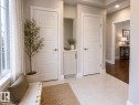 Entryway featuring light tile flooring, white baseboards, and two paneled interior doors - 7274 Morgan Road, Edmonton, AB 