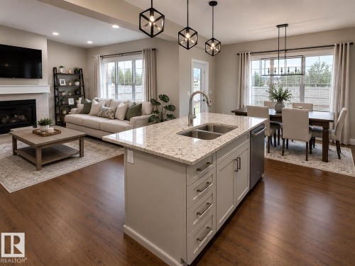 Kitchen island featuring a dual-basin stainless steel sink with a high-arc faucet, light-toned countertop, and light gray cabinetry with brushed nickel hardware - 7274 Morgan Road, Edmonton, AB 