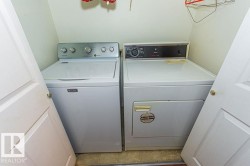 Dedicated laundry area featuring a white top-load washing machine and a white electric dryer - 