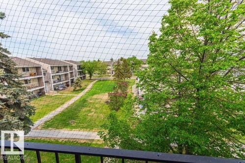Expansive green space featuring a manicured lawn, established trees, and paved walkways - 6 3819 76 Street, Edmonton, AB 