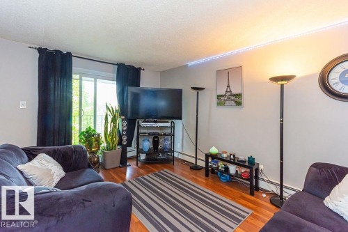 Wood-finish flooring anchors this space with a sliding glass door providing natural light - 6 3819 76 Street, Edmonton, AB 