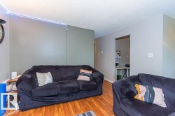 Interior space featuring wood-finish flooring, light gray walls, and an open doorway providing access to another area - 