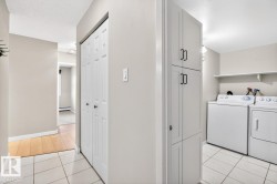 Utility area featuring white paneled cabinetry, tile flooring, and a wall-mounted shelving unit - 