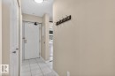 Entryway featuring white panel doors, square tile flooring, and a flush mount ceiling light - 405 10545 Saskatchewan Drive, Edmonton, AB 