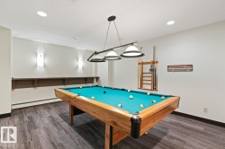 Recreation room featuring a pool table with an overhead light fixture, wood-finish flooring, recessed lighting, wall sconces, and a built-in wall shelf - 