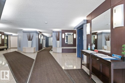 Spacious entryway featuring light tile flooring and dark accent rugs - #405 10545 Saskatchewan Dr Nw, Edmonton, AB - Indoor Photo Showing Other Room