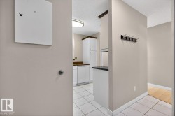 Kitchen entry with white tiled flooring and white baseboards - 