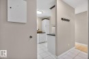 Kitchen entry with white tiled flooring and white baseboards - 405 10545 Saskatchewan Drive, Edmonton, AB 