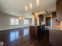 Open-concept living space featuring wood-finish flooring, multiple windows, and recessed lighting - 