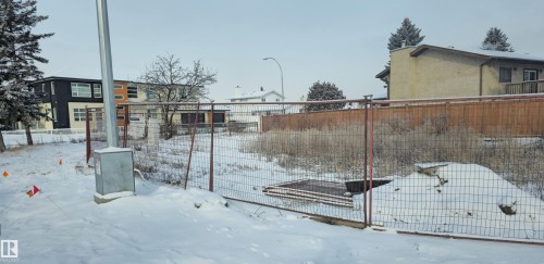 Fenced lot featuring a partially cleared area and surrounding residential structures - 6004 19A Avenue Nw, Edmonton, AB 