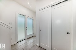 Entryway featuring frosted glass double doors, white trim, recessed lighting, and tile flooring - 