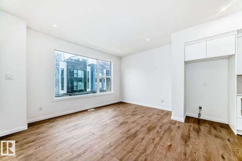 Bright interior space featuring wood-finish flooring and white walls - #67 5 Rondeau Dr, St. Albert, AB - Indoor Photo Showing Other Room