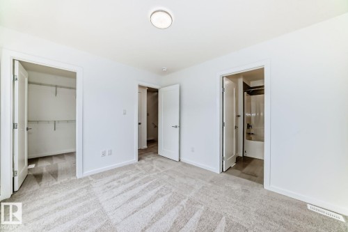 Neutral-toned carpeting spanning the room, complemented by white walls and trim - #67 5 Rondeau Dr, St. Albert, AB - Indoor Photo Showing Other Room