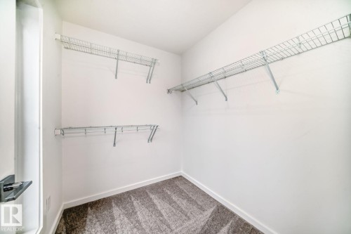 Spacious closet featuring white walls, wire shelving, and patterned gray carpeting - #67 5 Rondeau Dr, St. Albert, AB - Indoor With Storage