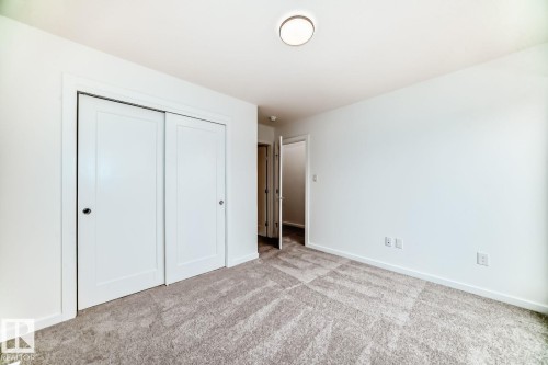 Room featuring neutral-toned carpeting, white walls, and a flush-mount ceiling light - #67 5 Rondeau Dr, St. Albert, AB - Indoor Photo Showing Other Room