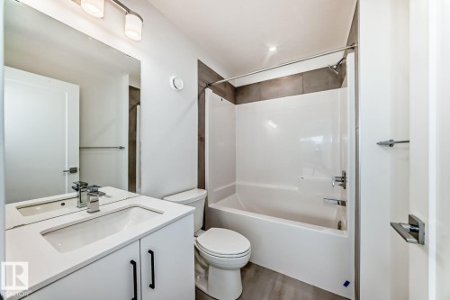 Bathroom featuring a modern vanity with integrated sink, white cabinetry, and matte black hardware - #67 5 Rondeau Dr, St. Albert, AB - Indoor Photo Showing Bathroom