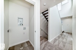 Dedicated laundry area with tile flooring and utility hookups - 