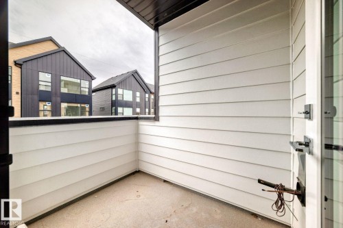 Outdoor balcony featuring horizontal panel siding, a concrete floor, and a black-capped half-wall - #67 5 Rondeau Dr, St. Albert, AB - Outdoor With Exterior