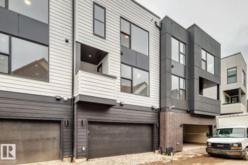 Modern townhome exterior featuring multi-level architecture with large pane windows, a private balcony, and an attached two-car garage - #67 5 Rondeau Dr, St. Albert, AB - Outdoor With Exterior