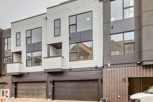 Contemporary townhome exteriors featuring multi-level facades with light and dark siding, large windows, and integrated garage doors - #67 5 Rondeau Dr, St. Albert, AB - Outdoor