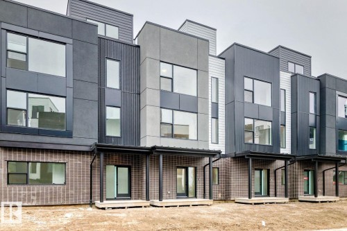 Modern townhome exteriors featuring multi-toned paneling and brick accents - #67 5 Rondeau Dr, St. Albert, AB - Outdoor