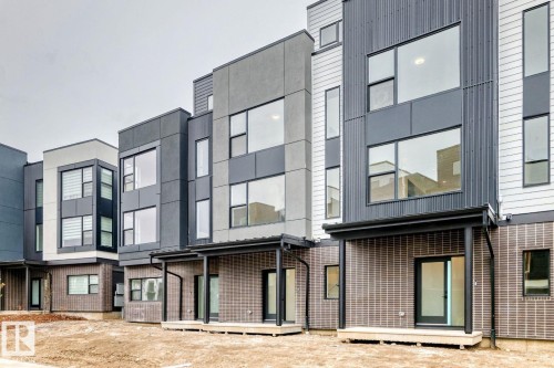Modern multi-level townhome featuring a mixed-material facade with vertical siding, stucco, and brick detailing - #67 5 Rondeau Dr, St. Albert, AB - Outdoor