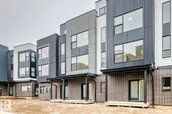 Modern multi-level townhome featuring a mixed-material facade with vertical siding, stucco, and brick detailing - 