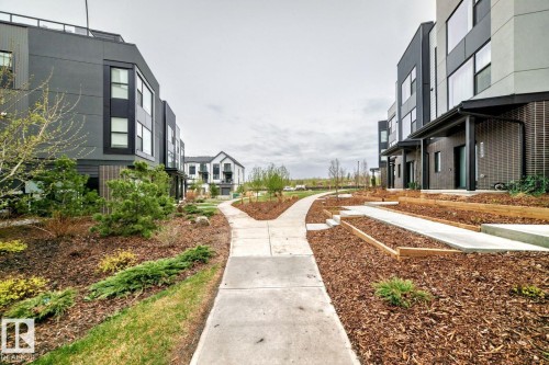 Modern townhomes featuring a contemporary architectural design, multiple windows, and covered entryways - #67 5 Rondeau Dr, St. Albert, AB - Outdoor