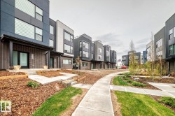 Modern multi-level exterior architecture featuring broad windows and a covered entry - 