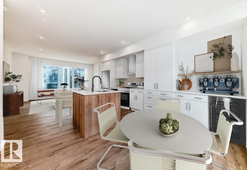 Open-concept kitchen featuring wood-finish flooring and a central island with a wood base and light-toned countertop - #67 5 Rondeau Dr, St. Albert, AB - Indoor