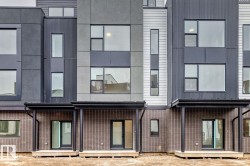 Modern townhouse exteriors featuring a combination of gray and white horizontal siding, corrugated metal accents, and brick facades - 